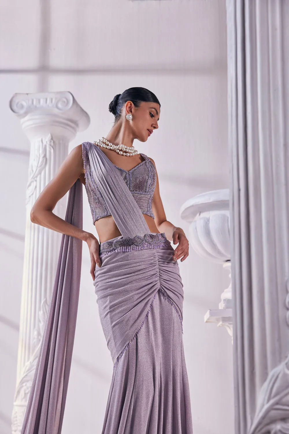 Draped Saree In Luxurious Shimmer Lycra Designed In Lilac Colour, An Emroidered Corset And A Belt.