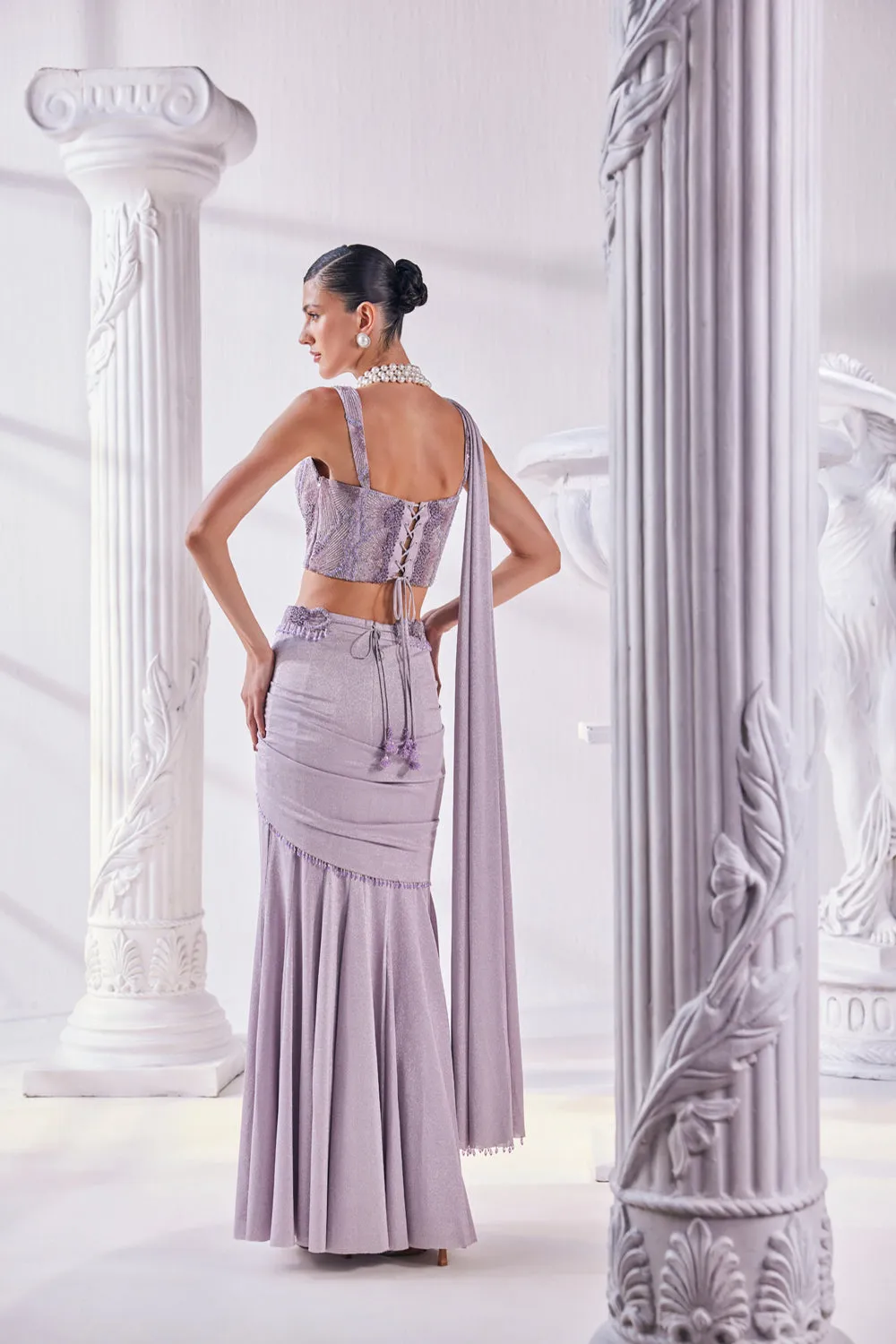 Draped Saree In Luxurious Shimmer Lycra Designed In Lilac Colour, An Emroidered Corset And A Belt.